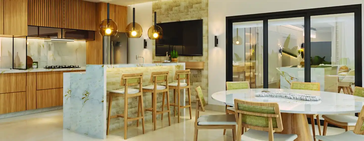 Cozinha com ilha em pedra natural, banquetas de madeira e mesa redonda ao fundo