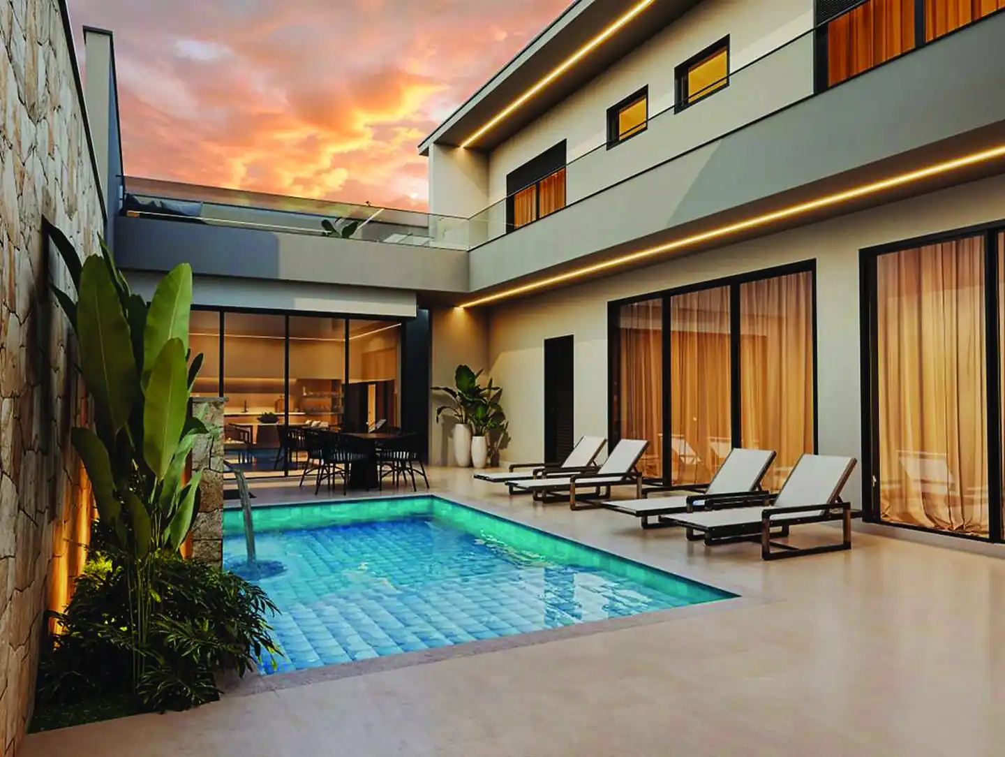 Piscina da Casa Veneza com espreguiçadeiras e fachada envidraçada ao entardecer